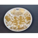 A ROSENTHAL BJORN WIINBLAD PLATE GILT WITH BIRDS, FIGURES AND ANIMALS BELOW A TREE. Dia. 22cms.