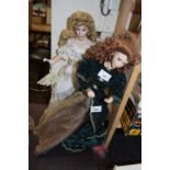 A porcelain doll on stand, formed as a lady in cream gown with floral detail, with plastic and