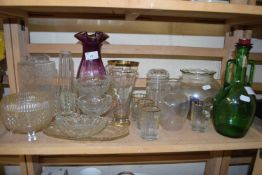 Group of drinking glasses and green glass bottle