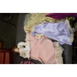 A porcelain doll on stand, formed as a Victorian lady in pink dress and floral jacket. Height