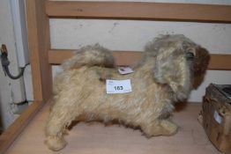 A vintage straw-stuffed dog. No makers mark, some repairs and in need of tlc.