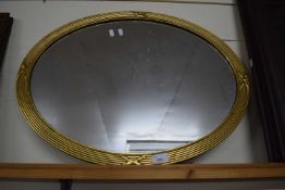 20th Century oval wall mirror in ribbed gilt frame