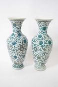 Pair of continental porcelain vases decorated in green enamel with foliage and birds (repair to neck