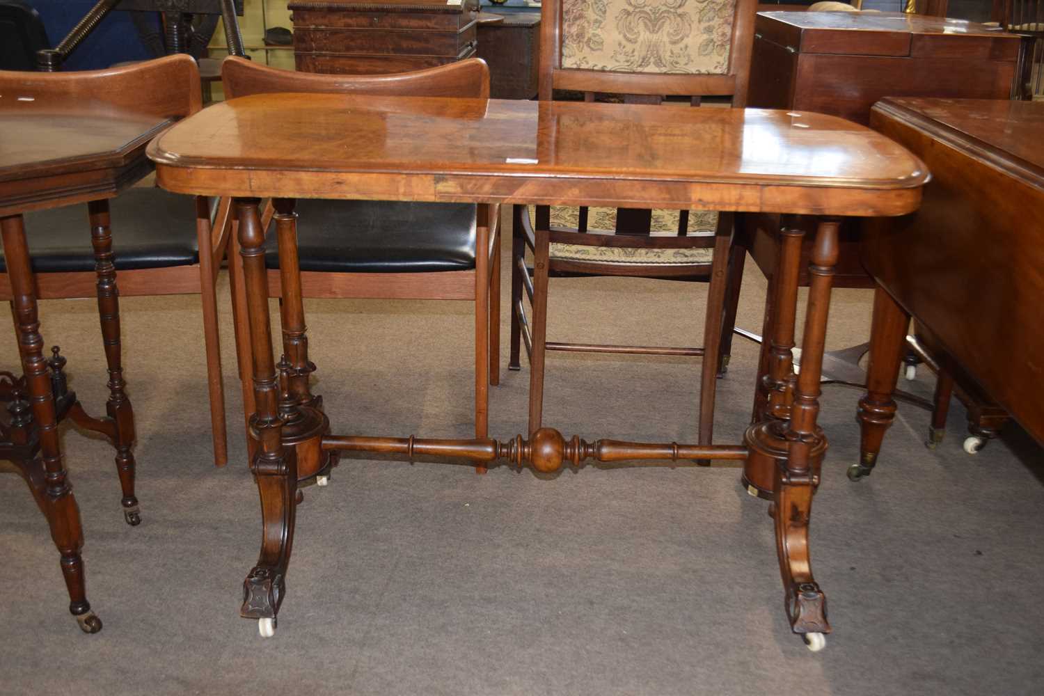 Victorian walnut veneered centre table raised on four turned supports with outswept legs with