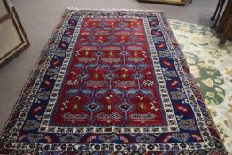 Large 20th Century Middle Eastern carpet decorated with geometric design on a principally red and