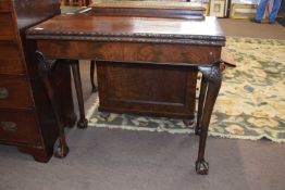 Late 19th Century walnut card table with folding top over shell carved knees and ball and claw feet,