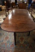 A large 19th Century mahogany sectional dining table formed of two drop leaf end sections with a