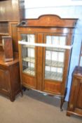 Edwardian mahogany and inlaid china display cabinet of bow front form with two lead glazed doors,