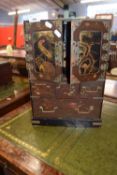 Late 19th or early 20th Century Oriental lacquered table top cabinet with two panelled doors opening