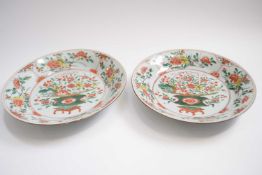 A pair of 18th century Chinese porcelain dishes decorated in famiile vert with a basket of flowers