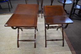 Pair of reproduction mahogany coaching style tables with folding rectangular tops