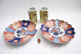 Two Japanese Imari plates together with two small cylindrical vases, the yellow ground decorated