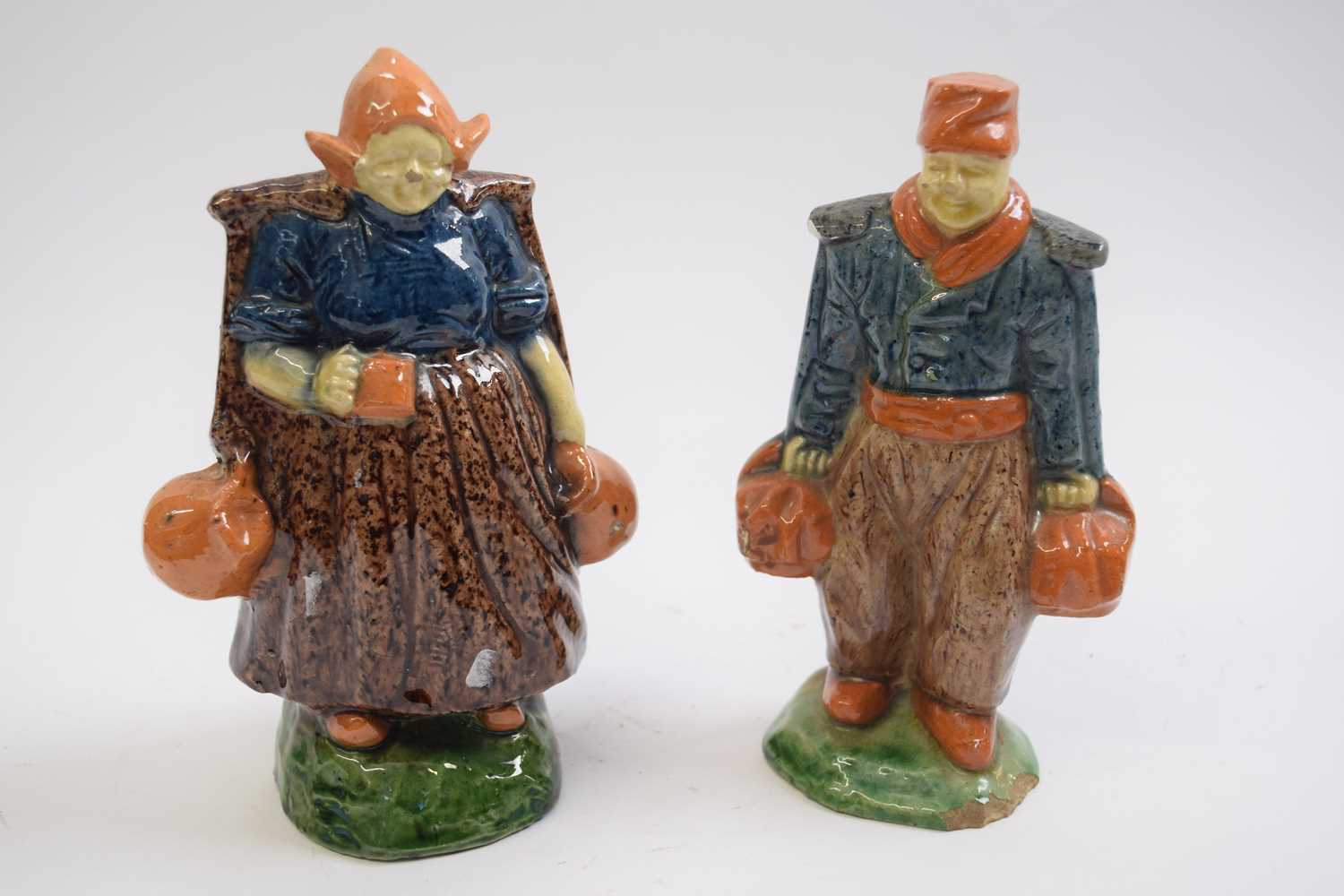 Pair of early 20th Century Dutch pottery figures of a boy and a girl in Maiolica style glazes