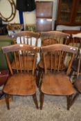Set of four late 19th or early 20th Century elm seated stick back kitchen chairs