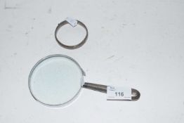 Small silver bangle together with a magnifying glass