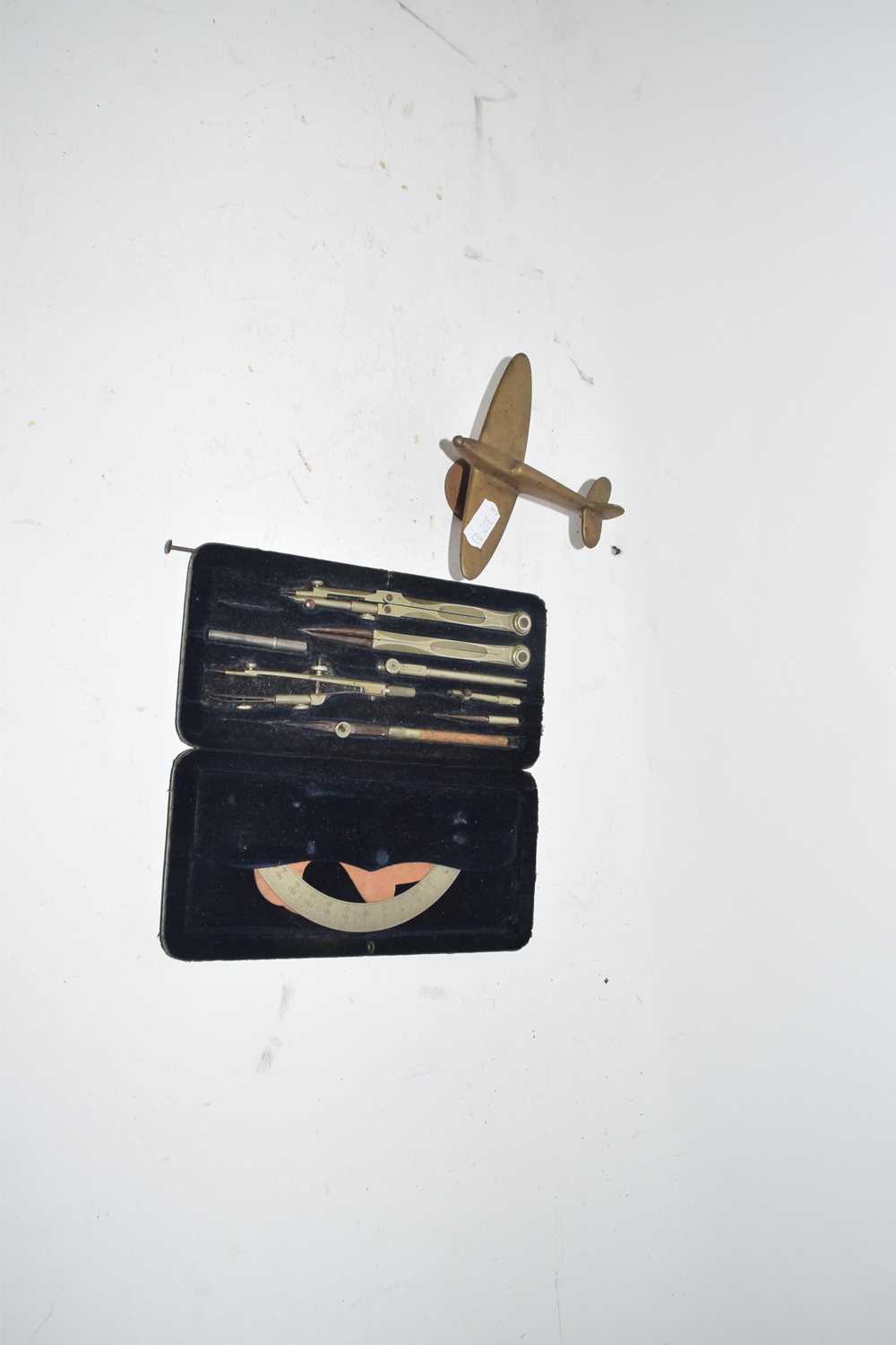 Cased set of vintage drawing instruments and a small desk ornament formed as a WW2 aeroplane