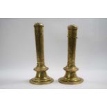 Pair of brass candle holders with covers with medieval designs, 25cm high