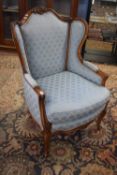 19th Century continental wing back armchair upholstered in blue fabric, frame decorated with