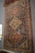 Antique Middle Eastern wool floor rug decorated with three large central lozenges surrounded by a