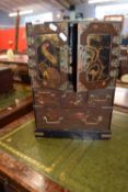 Late 19th or early 20th Century Oriental lacquered table top cabinet with two panelled doors opening
