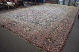 Extremely large faded caucasian wool rug decorated with a large central panel of floral motifs on
