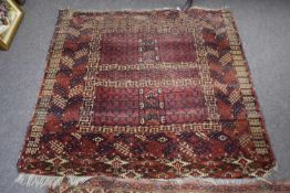 Antique Middle Eastern wool floor rug decorated with central red panel, appears to be a fragment