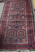 Small Middle Eastern wool floor rug decorated with a central panel of octagonal lozenges on a mainly