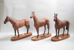 Group of three Beswick racehorses including Najinski, Red Rum and Arkle, all mounted on oval