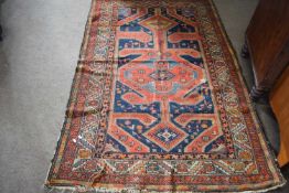 Middle Eastern wool rug decorated with large central panel in principally red and blue, 192 x 124