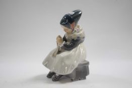 Royal Copenhagen model of a young girl seated on a bench sewing, 17cm high