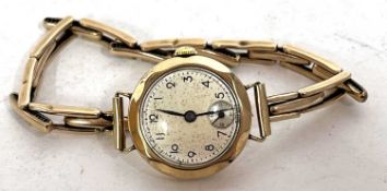 A ladies 9ct gold cased wrist watch on a 9ct gold expanding bracelet, the watch has a manually crown