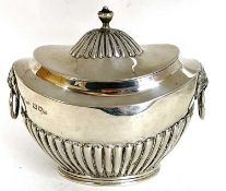 A hallmarked silver tea caddy of oval form, the hinged lid with fluted detail and urn finial, the