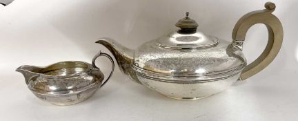 A George V silver teapot and cream jug of compressed circular form with reeded detail, the teapot
