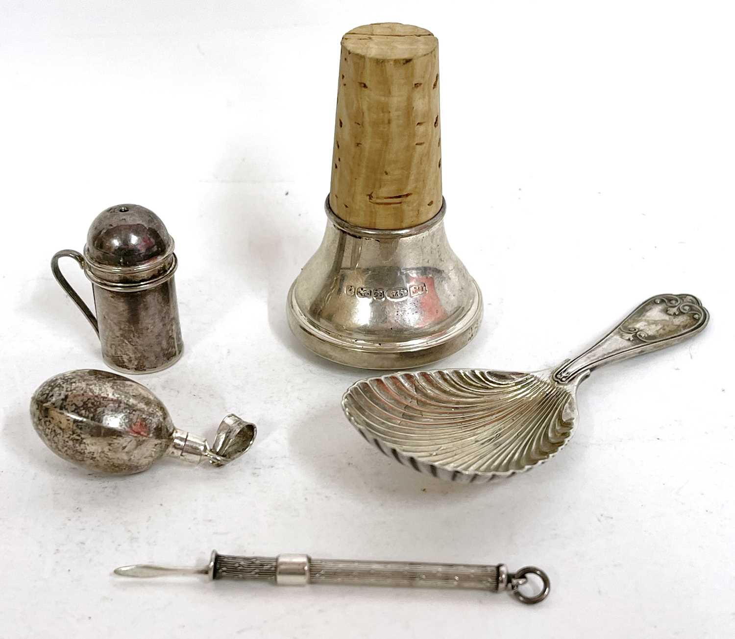 Mixed lot to include a silver cased toothpick, a white metal and cork bottle stopper, plated shell
