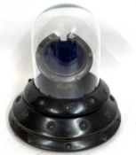 A pocket watch display stand, the base of the stand is wood and features a blue fabric interior