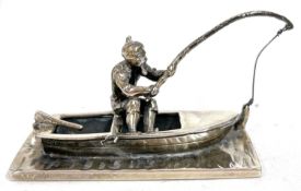 A white metal paperweight modelled as a fisherman and boat, import mark for 1979, 5cm x 2.5cm
