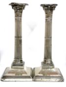 A pair of Corinthian column silver candlesticks with detachable beaded sconces, loaded bases, London