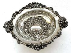 An Edwardian oval shaped dish applied with floral and scrolled border, the centre embossed with