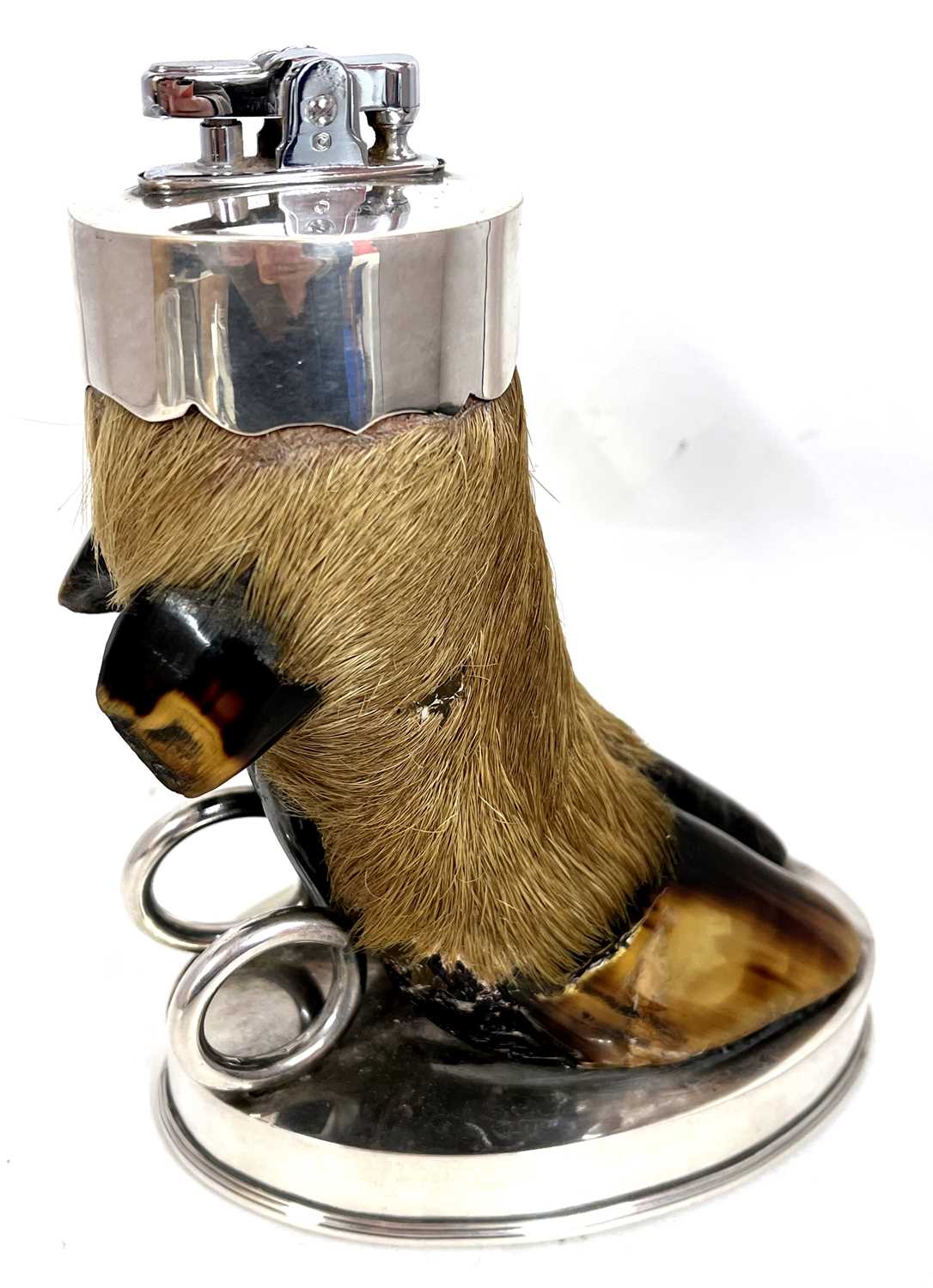 A Vintage Ronson table lighter mounted as a deers foot to an oval shaped loaded silver plate base,