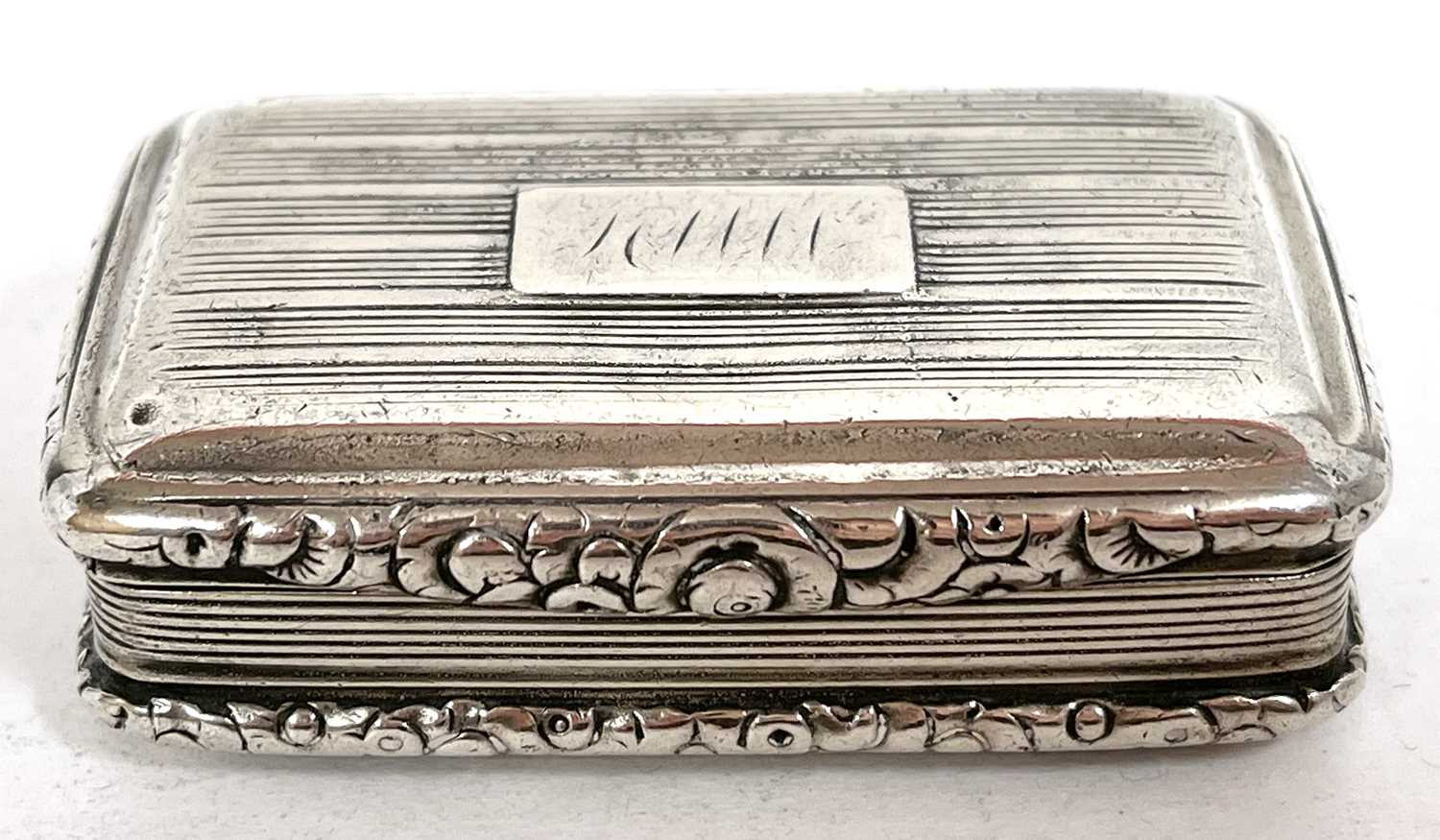 An antique silver snuff box with reeded decoration around an initialled cartouch, the edges