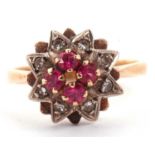 Ruby and diamond cluster ring the centre with four small round cut rubies raised above a star
