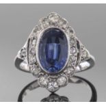 Precious metal, diamond and blue stone cocktail ring, the bezel set oval cut centre blue stone