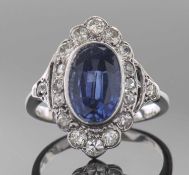 Precious metal, diamond and blue stone cocktail ring, the bezel set oval cut centre blue stone