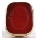 A carnelian intaglio ring, the rectangular panel engraved with initials inside a belt and buckle