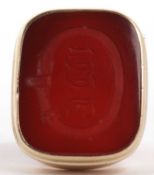 A carnelian intaglio ring, the rectangular panel engraved with initials inside a belt and buckle