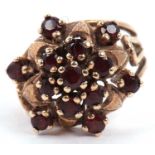 Garnet set cluster dress ring raised between split shoulders, marks rubbed, tested for 9ct gold, g/w