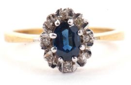 18ct gold sapphire and diamond cluster ring, the oval cut sapphire raised above a small diamond