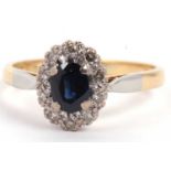 18ct stamped blue stone and diamond cluster ring, the oval centre stone within a small round