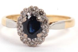 18ct stamped blue stone and diamond cluster ring, the oval centre stone within a small round