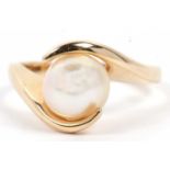 A modern pearl single stone ring set between crossover angular shoulders, stamped 14k, size M